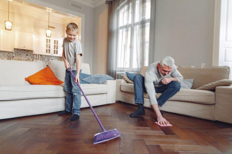 A grandfather and grandson enjoy quality time cleaning their living room together.